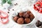 Homemade chocolate candy truffles with candy canes on white table.