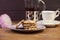 Homemade chocolate chip cookies on a beautiful saucer, kettle of tea, on a wooden dark background