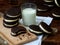 Homemade chocolate cookies with white marshmallow cream and glass of milk on dark background.