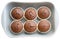 Homemade chocolate cupcakes in ceramic baking tray. Each muffin in a separate paper baking dish. Isolated on white