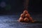 Homemade Chocolate Truffles in Glass with Sifting Cocoa on Dark Stone Table and Background. Copy Space