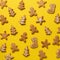 Homemade christmas cookies on yellow background. Square crop. Pattern of gingerbread men, snowflake, star, fir-tree, boot shapes.