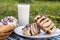 Homemade cinnabons cinnamon buns with cream cheese glaze and chocolate icing and glass of milk.