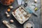 Homemade cinnamon rolls buns with white cream icing ,word cooking time made of white flour, blue whisk and egg shell on grey dark