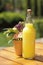 Homemade citrus limonade in bottle on the table with flowers