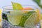 Homemade cocktail with citrus fruits in glass cup with transparent drink and ices