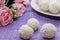 Homemade coconut candy on a background of pink flowers. Sweets for Valentine`s Day