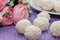 Homemade coconut candy on a background of pink flowers. Sweets for Valentine`s Day