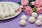 Homemade coconut candy on a background of pink flowers. Sweets for Valentine`s Day