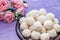 Homemade coconut candy on a background of pink flowers. Sweets for Valentine`s Day