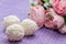 Homemade coconut candy on a background of pink flowers. Sweets for Valentine`s Day