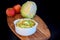 Homemade coleslaw salad in a white plate with cabbage and apple on a wooden board on a black background.
