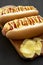 Homemade colombian hot dog with chips, yellow mustard, mayo ketchup and pineapple sauce, side view. Close-up