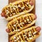 Homemade coney island hot dogs on a rustic wooden board on a white wooden background, top view. Flat lay, from above, overhead