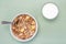 Homemade cooked oatmeal cereals with ceramic mug, metal spoon and glass of milk above view on blue background