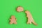 Homemade cookies in shapes of dinosaur and man with inscription â€˜Stay homeâ€™ on green background, top view.