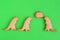 Homemade cookies in shapes of dinosaurs with inscription â€˜Stay homeâ€™ on green background, top view.