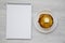 Homemade corn meal Johnny cakes with butter on a white plate, blank notepad on a white wooden background. Flat lay, overhead, from