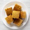 Homemade Cornbread Ready to Eat on a white plate over white wooden background, top view. Flat lay, overhead, from above