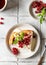 Homemade cottage cheese casserole garnished with sauce, redcurrant and cup of coffee on gray tile background, top view