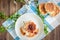 Homemade cottage cheese pancakes on blue plate with spring cherry plum branches on wooden background