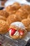 Homemade Craquelin Choux biscuits crispy cream puffs with cream filling and Strawberries on rack