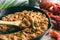 Homemade crawfish etouffee in a cast iron pan. Shown with whole boiled crawfish on a wood background.