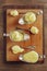 Homemade creamy mash potato in three silver cups and spoons in wooden plate and table, top down vertical view.