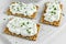 Homemade Crispbread toast with Cottage Cheese and parsley on white wooden board.