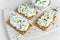 Homemade Crispbread toast with Cottage Cheese and parsley on white wooden board.