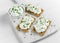 Homemade Crispbread toast with Cottage Cheese and parsley on white wooden board.