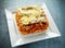 Homemade Crispy lasagna in iron pan with minced beef bolognese sauce, parmesan cheese