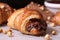 homemade croissant, filled with chocolate hazelnut spread and topped with toasted hazelnuts