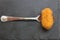 A homemade croquette on a fork on a black slate plate