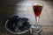 Homemade dark damson plum brandy in glasses on a wooden table, closeup. Drink from dry plums