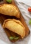 Homemade Deep Fried Italian Panzerotti Calzone on a rustic wooden board on a white wooden surface, top view. Flat lay, overhead,