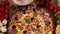 Homemade delicious pizza in round pan with fresh ingredients around - closeup