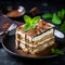 Homemade Delicious Tiramisu cake decorated with fresh mint on a black stone table concrete background