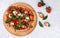 Homemade dessert pizza with tomato sauce, strawberries, burrata cheese, green Basil and balsamic