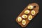 Homemade Deviled Eggs with Chives on a rustic wooden board on a black background, top view. Flat lay, overhead, from above. Copy