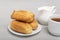 Homemade eclairs and tea with milk. Traditional French eclairs. Profiteroles on white saucer