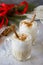 Homemade Eggnog Christmas milkshake with cinnamon, served in two cups on a stone or slate background, decorative ornaments,