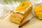 Homemade exotic mango pie with whipped cream, decorated with pieces of mango on beige background. Pound cake