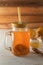 Homemade fermented drink Kombucha in glass jar with lemon, honey and ginger on a wooden table.