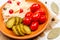Homemade fermented products on a plate - sauerkraut, tomatoes, pickles on a white background