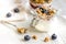 Homemade fitness granola with yoghurt and berries on white kitchen background