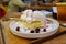 Homemade Fluffy Japanese Pancakes with berry sauce and ice cream topping on a white plate