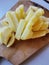 Homemade food. Sliced potatoes. French fries. Cooking food. Wooden board.