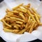 Homemade french fries on a baking sheet on a black background, side view. Close-up