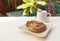 Homemade French spiral Chocolate danish with hot coffee on wooden table over blurred garden and pool background